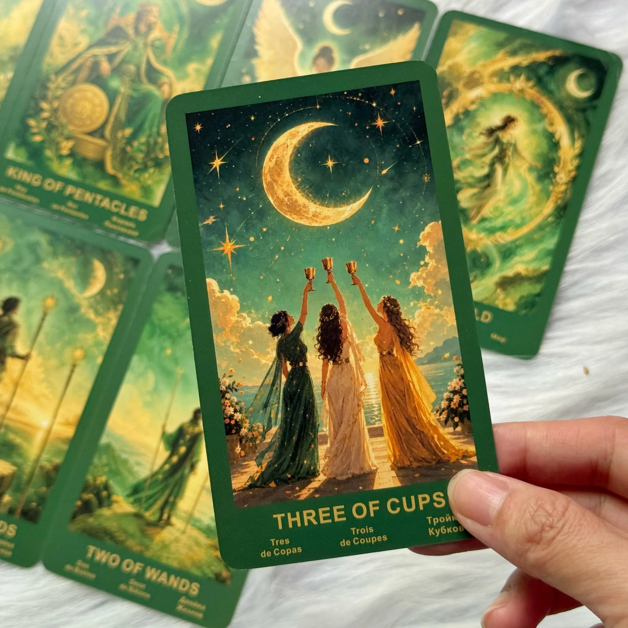 Carte Trois de Coupes montrant trois personnages sous un croissant de lune